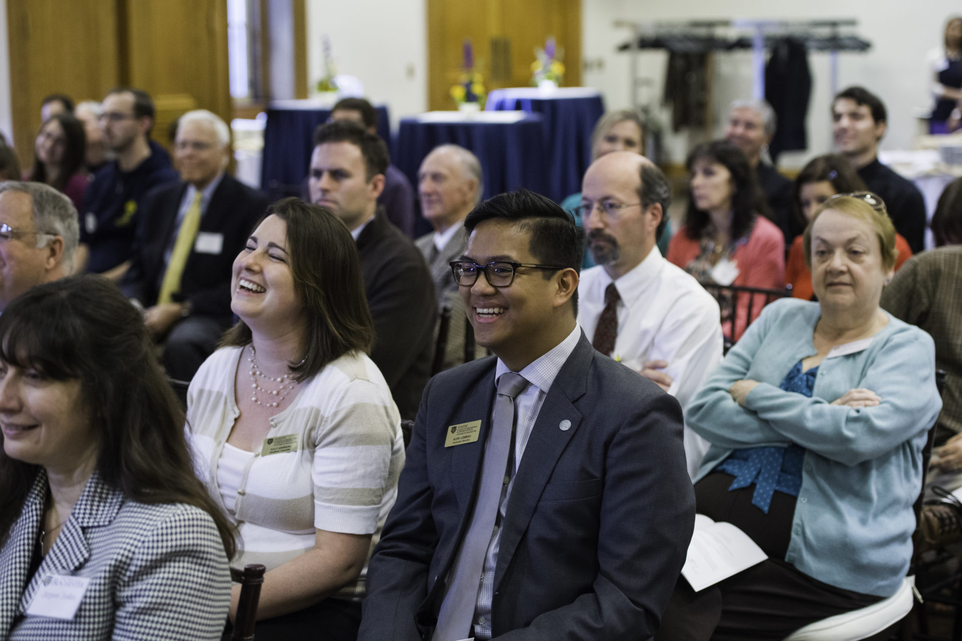 University faculty and staff laugh during a ceremony on the River Campus