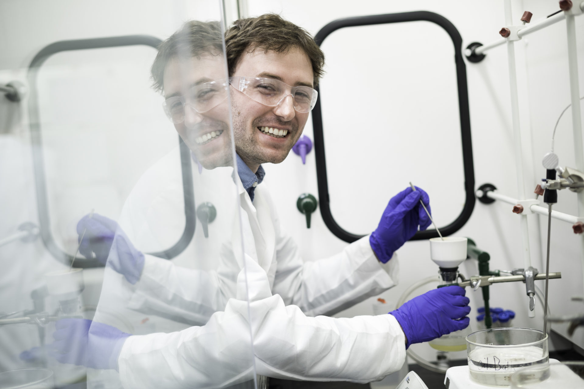 University of Rochester student in a laboratory wearing goggles and gloves