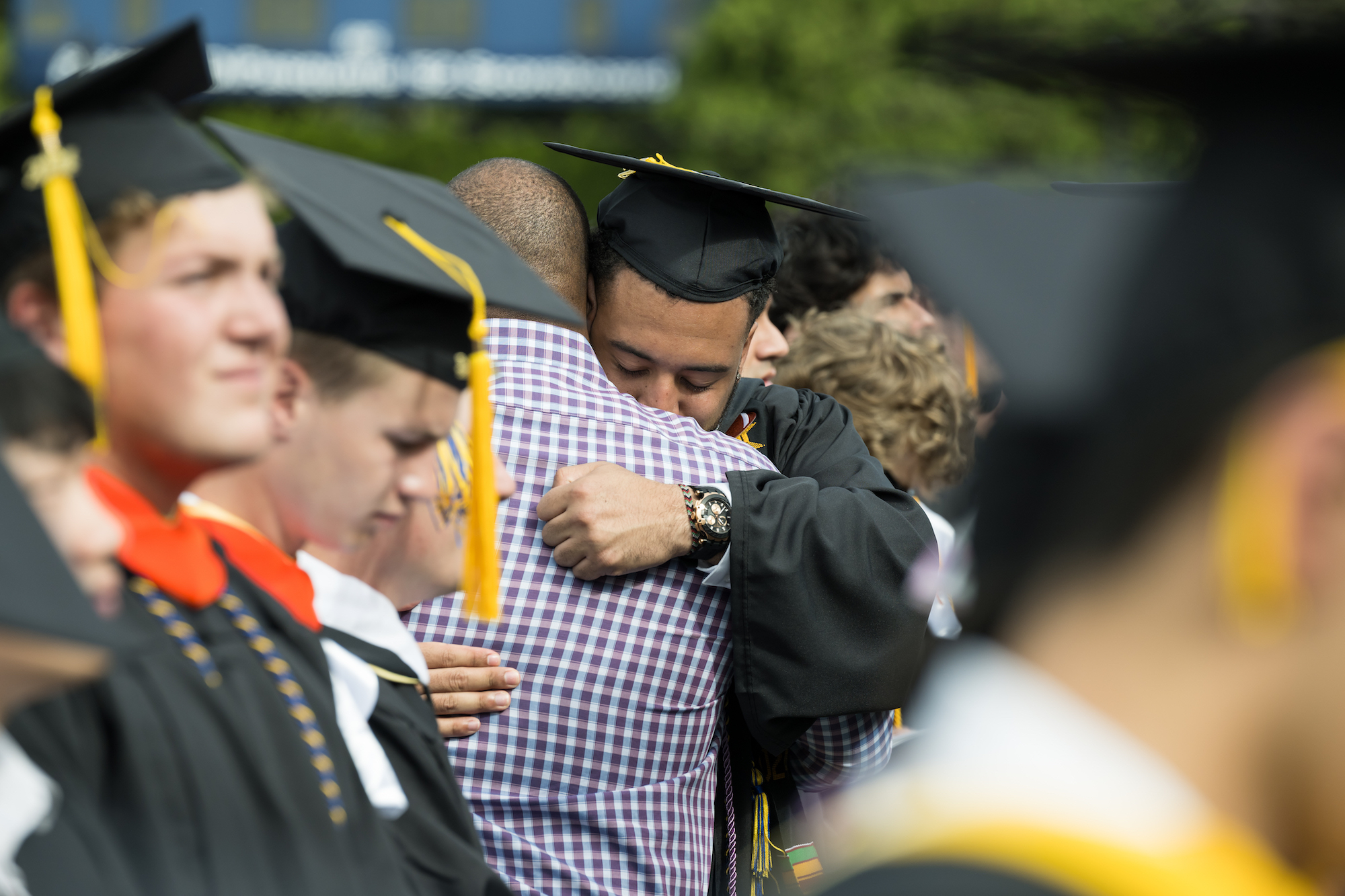 Xavier Green gets a hug from his father Bobby during the processional of the University's Commencement ceremony