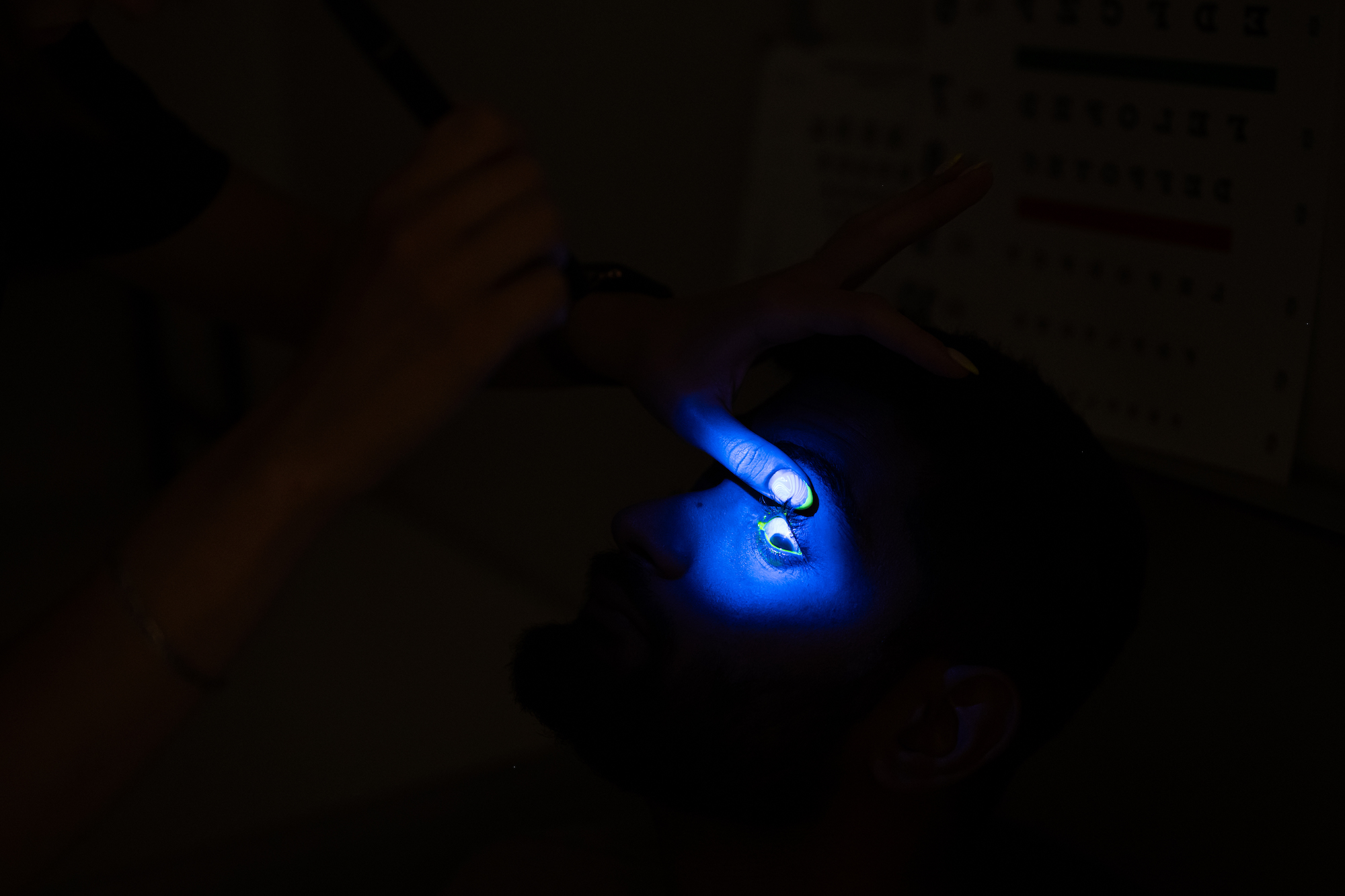 First-year graduate student Alina Neveroska uses blue light and a special dye to check for corneal abnormalities in the eyes of post-doctoral student and test subject Krish Prahalad