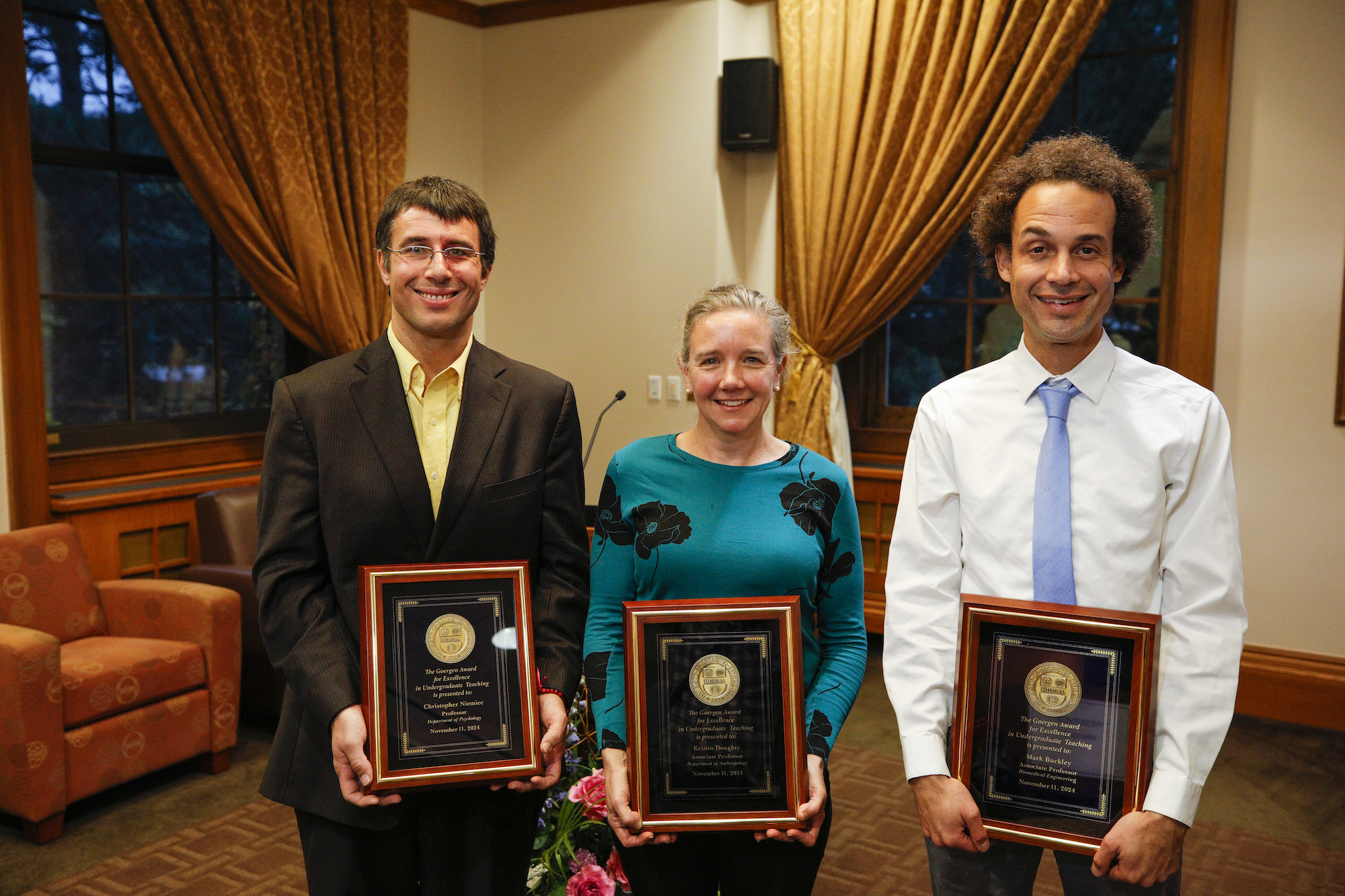 Three recipients of the Goergen Awards for Excellence in Undergraduate Teaching holding framed awards