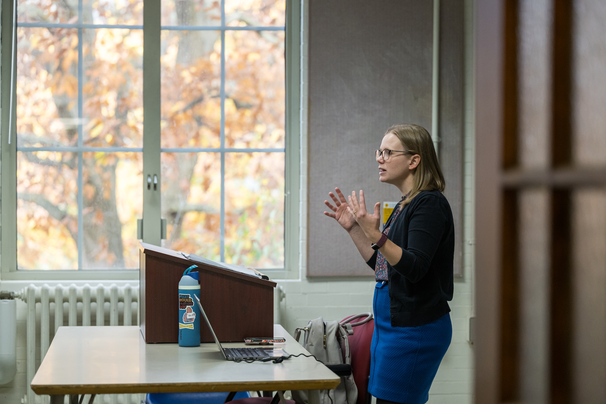 Profile of a professor standing at the front of a classroom