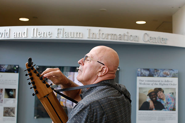 Bob Pizzutiello ’77, ’78 (MS) plays the Chapman Stick in the lobby of Strong Memorial Hospital.